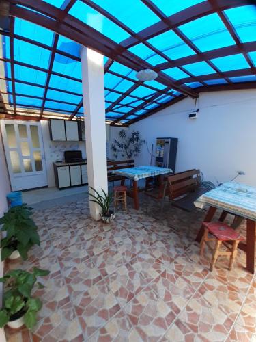 a patio with two tables and a blue ceiling at CASA IZA in Băile Herculane