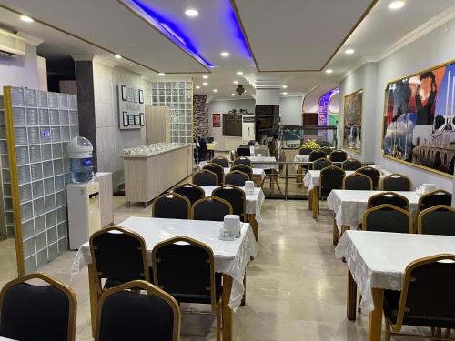 a dining room with white tables and chairs at Balkan Palace Edirne in Edirne