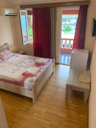 a bedroom with a bed and a table and a window at Guest House Rusalka in K'obulet'i