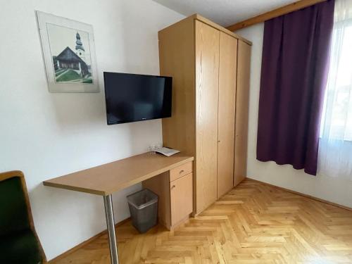 a room with a desk and a tv on a wall at Rosental Apartments Self Check-in in Ferlach