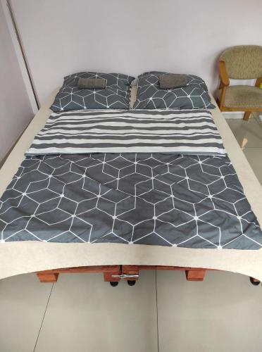 a bed with a black and white comforter at Agroturystyka "U Źródła" in Milicz