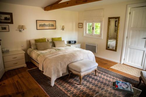 a bedroom with a large bed and a mirror at L'Oisette in Epiniac