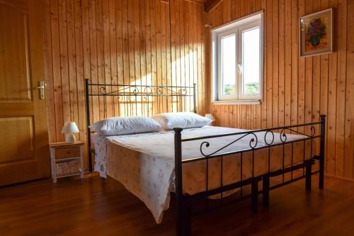 a bedroom with a bed in a wooden wall at Apartman Bella vista in Veli Iž