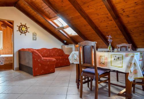 a living room with a table and a couch at Apartman Bella vista in Mali Iž