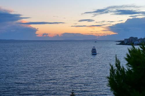 un barco en un gran cuerpo de agua al atardecer en Hotel Havana, en Sarandë