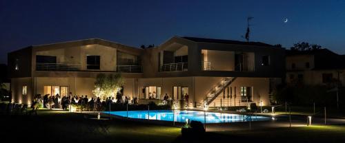 a group of people standing outside of a building at night at COBUE "Wine resort & Spa" in Pozzolengo