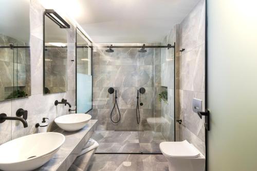 a bathroom with two sinks and a shower at Heaven Hotel Thessaloniki Airport in Néon Rýsion