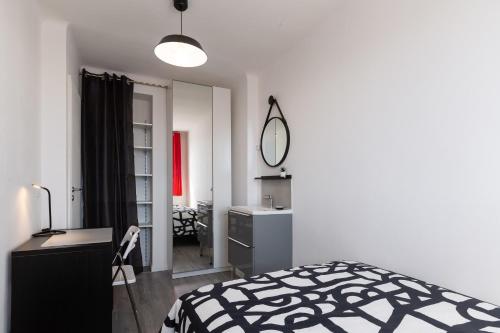 een slaapkamer met een zwart-wit bed en een spiegel bij Massilia Holidays in Marseille