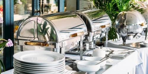 una mesa con platos blancos y cuencos en una mesa en Shahzoda Grand Hotel - "Best Hotel Award Winner", en Solnechnyy