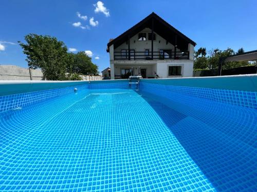 a swimming pool with a house in the background at Garden Villa in Braşov