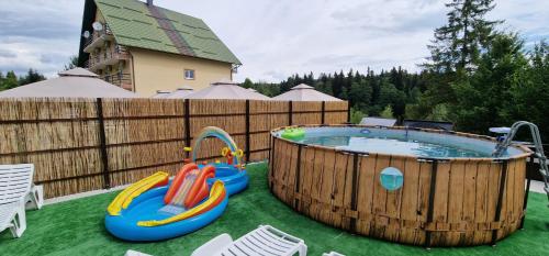 una gran bañera de hidromasaje de madera con 2 zonas de juegos inflables en Poiana Bucovat, en Gura Humorului