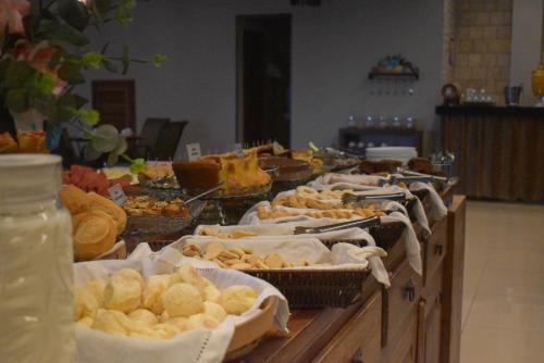 a buffet with many different types of bread and pastries at Pousada Maria Monteiro Tiradentes in Tiradentes
