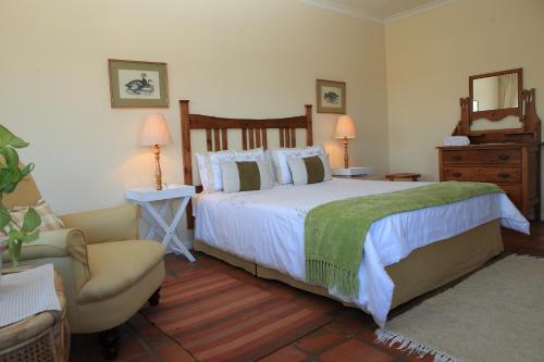 a bedroom with a bed and a couch and a chair at Yellowwood Lodge in Knysna