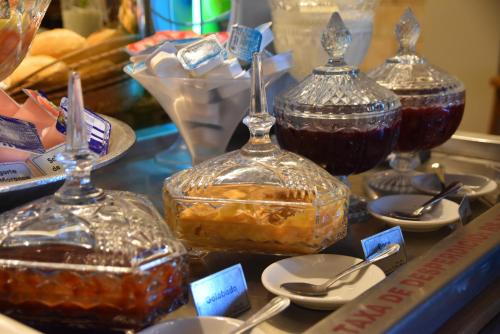 a display of desserts in glass jars on a table at Pousada Maria Monteiro Tiradentes in Tiradentes