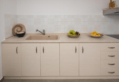 a kitchen with a sink and two baskets of fruit at Kanelis Milos Sea Suite in Agia Irini Milos