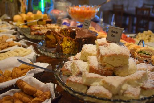 a buffet of different types of cakes and pastries at Pousada Maria Monteiro Tiradentes in Tiradentes
