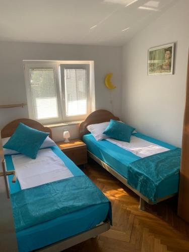 a room with two beds and two windows at Apartmani Auer in Pješčana Uvala
