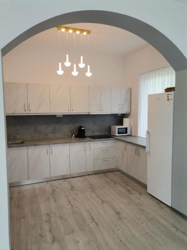 a kitchen with white cabinets and a white refrigerator at Vila President Sovata in Sovata