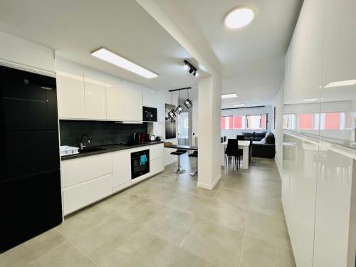 cocina con armarios blancos y comedor en Apartamento Parque Jardín, en Las Palmas de Gran Canaria