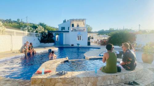 een groep mensen die rond een zwembad zitten bij The Dragonfly Retreat in Málaga