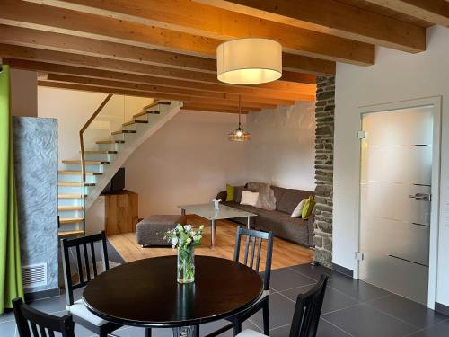 a dining room and living room with a table at Ferienhaus Eifelherz in Simmerath