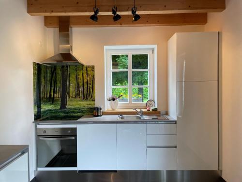 a kitchen with a white refrigerator and a window at Ferienhaus Eifelherz in Simmerath