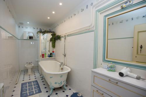 a bathroom with a tub and a toilet and a sink at Hotel des Etrangers in Saint-Martin-dʼEntraunes