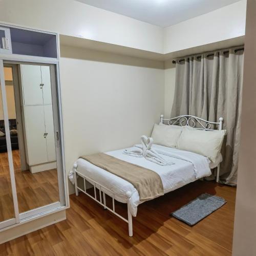 a small bedroom with a bed and a mirror at Avida Davao Condos, downtown CM Recto Avenue, Davao City in Davao City