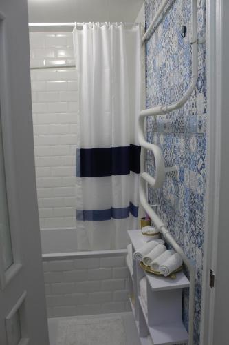 uma casa de banho com uma cortina de chuveiro azul e branco em Тиффани апартаменты em Dnipro