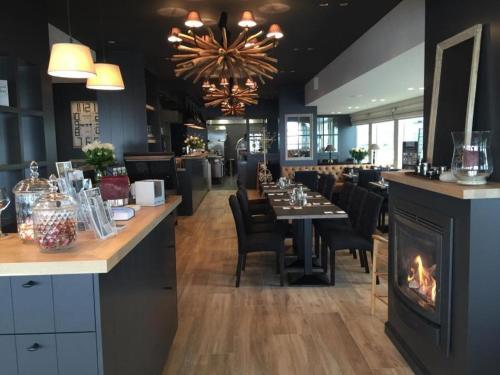 a restaurant with a fireplace and a dining room at Le Sable Doux 8D in Middelkerke