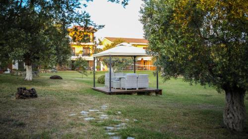 a gazebo with two white chairs in a park at Saint George Sithonia in Neos Marmaras