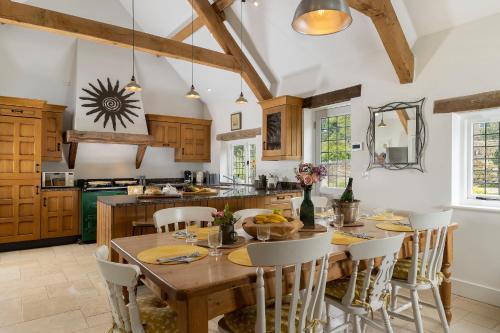 a kitchen with a large wooden table and chairs at Blenheim Cottage, Beautiful 15th Century Cotswold Cottage, 4 Bed, Nr Chipping Campden in Mickleton