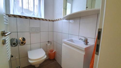 a small bathroom with a toilet and a sink at City Apartment Hanau in Hanau am Main