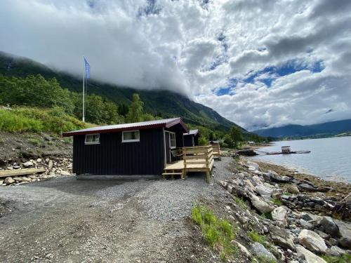 Tresfjord的住宿－Fagervik Camping，湖岸上的一个小棚屋