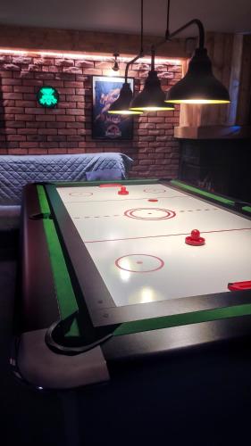 a ping pong table in a room with a pool table at Willa Ramzówka - Dom z Bilardem, Sauną i Jacuzzi in Nowy Sącz