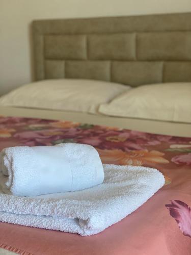 a white towel sitting on top of a bed at Pararse Apartments in Vlorë