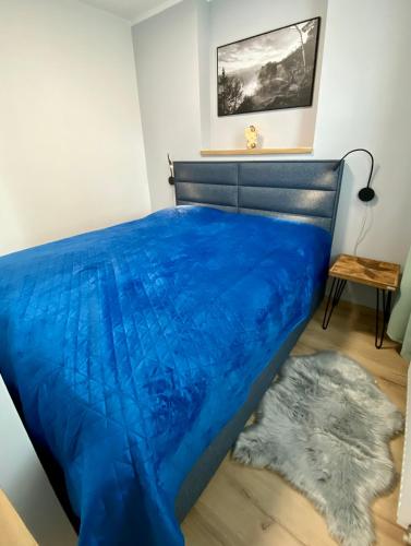 a bed with a blue comforter in a room at Berta's Apartments in Děčín