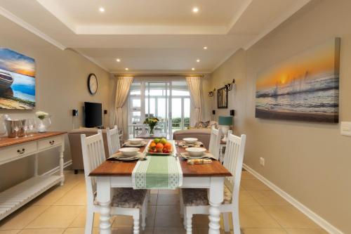 a kitchen and dining room with a table and chairs at Pinnacle Point 2-bedroom self-catering apartment in Mossel Bay