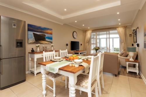 a kitchen and dining room with a table and chairs at Pinnacle Point 2-bedroom self-catering apartment in Mossel Bay