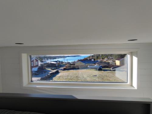 a window in a bedroom with a view of the ocean at New villa, 45sqm, 2 bedrooms, loft, 80m from beach, fantastic views & very quiet area in Onsala