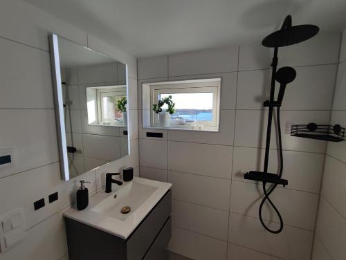 y baño con lavabo y espejo. en New villa, 45sqm, 2 bedrooms, loft, 80m from beach, fantastic views & very quiet area en Onsala