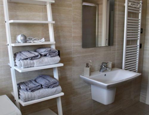 ein Bad mit einem Waschbecken, einem WC und Handtüchern in der Unterkunft Rho Fiera Milano - Popy House in Pero