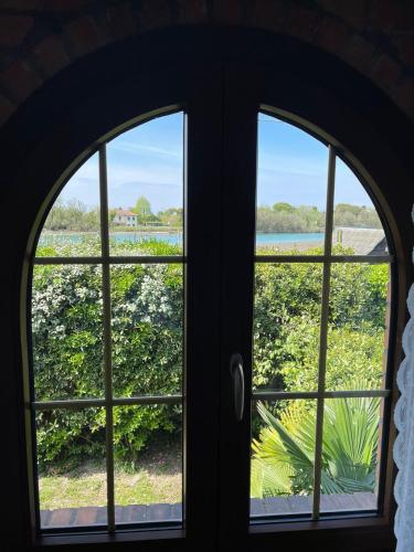 an arched window with a view of a garden at La Bricola in Cavallino-Treporti