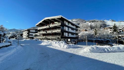 una carretera cubierta de nieve frente a un edificio en Haizelrock, en Kirchberg in Tirol