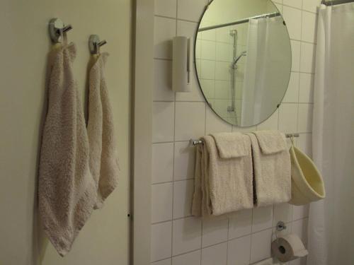 uma casa de banho com toalhas e um espelho na parede em Treetop Apartment em Haia
