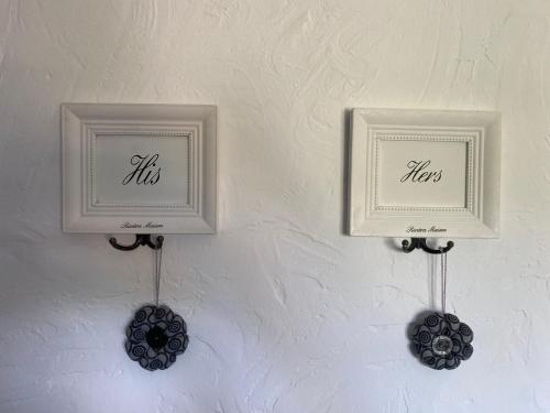 two white frames on a wall with flowers on it at La Bastide de Jean Maison de charme dans un domaine equestre privé in Grasse