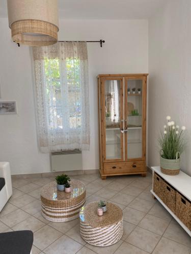 a living room with two tables and a cabinet at La Bastide de Jean Maison de charme dans un domaine equestre privé in Grasse