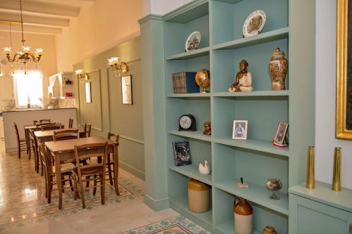 a dining room with a blue wall with shelves at Ta' Dun Martin and taz-Zija Bed and Breakfast in Nadur