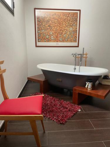 uma casa de banho com uma banheira, uma cadeira e um tapete em La casa dei caprioli appartamento in casale em Montepulciano