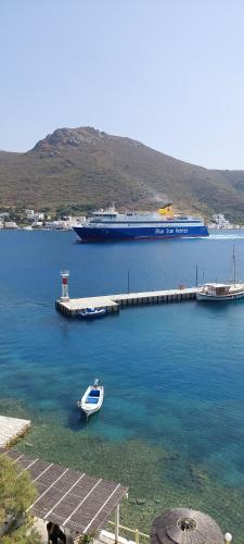 a boat is docked at a dock with a cruise ship at Kalliopis Rooms in Katapola